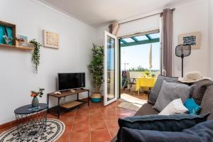 ein Wohnzimmer mit einem Sofa und einem TV in der Unterkunft sunny apartment with sea view in Tavira
