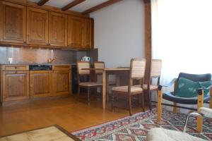 - une cuisine avec des placards en bois, une table et des chaises dans l'établissement Central for up to 7 guests, Flaminia, à Crans-Montana