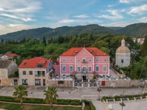 un groupe de bâtiments dans une ville avec des montagnes en arrière-plan dans l'établissement B&B Heritage Villa Apolon, à Stari Grad