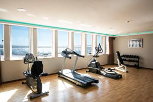 a gym with several exercise bikes in a room with windows at Vila Gale Ericeira in Ericeira