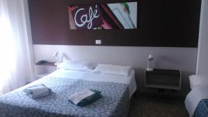 a hotel room with a bed with two towels on it at Radio Hotel in Rome