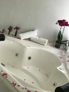una bañera blanca con flores encima en Hotel Fazenda Bom Retiro, en Quatis