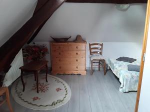 a bedroom with a bed and a dresser and a chair at Maison( Clesanie ) in Serquigny