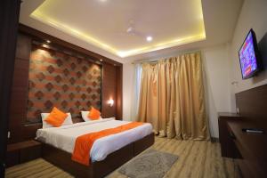een hotelkamer met een bed en een televisie bij Hotel Marygold in Agra