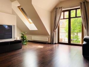 a living room with a television and a large window at Apartament in Szczytno