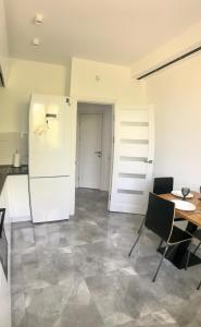 cocina con mesa y nevera blanca en Затишні та просторі апартаменти в новобудові en Ternopilʼ