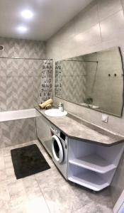 y baño con lavabo y espejo. en Затишні та просторі апартаменти в новобудові en Ternopilʼ