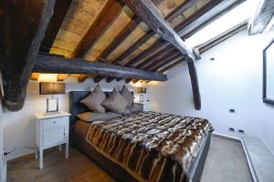 Un dormitorio con una cama grande y un techo de madera. en Easydomus Rome, en Roma