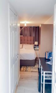 a bedroom with a bed and a desk and a door at Mimi's Private Compact and Cozy Ensuite in Netherton