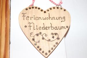 a wooden heart hanging on a door with the words transforming filletedalam at Brombergerhof Münsing in Münsing