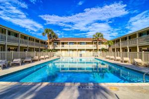a swimming pool in front of a building with chairs at Courtyard #113 in Port Aransas