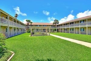 a large building with a green lawn in front of it at Courtyard #206 in Port Aransas