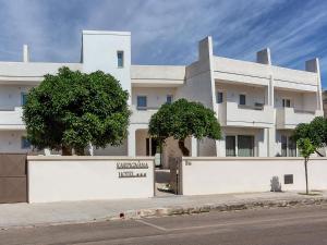 un edificio blanco al lado de una calle en Karpignàna Hotel en Carpignano Salentino