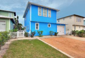 ein blaues Haus mit einem Garten davor in der Unterkunft Harpers Berry 5SC in Port Aransas