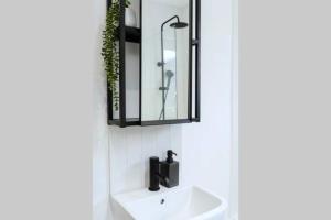 une salle de bain avec un lavabo et un miroir dans l'établissement Chic Beach Getaway (sleeps 6) - 4min walk to beach, à Kent 24 autres photos