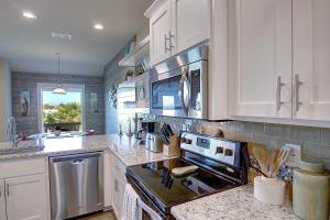 eine Küche mit weißen Schränken und einem Herd mit Backofen in der Unterkunft Saltwater Hippie in Port Aransas