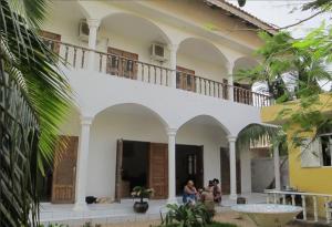 a group of people sitting outside of a building at Maison Tikani in Cotonou