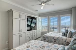 a bedroom with two beds and a flat screen tv at Channelview 305 in Port Aransas