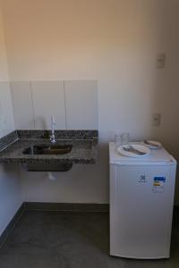 a kitchen with a sink and a small refrigerator at Chalés Magia Da Lua in Cavalcante