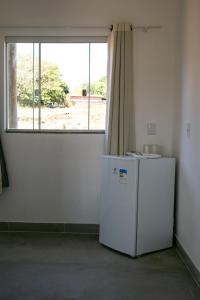 a white refrigerator in a room with a window at Chalés Magia Da Lua in Cavalcante