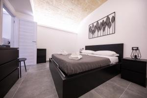 a bedroom with a large bed in a room at Amare Cefalù - Elegant Apartment in Cefalù