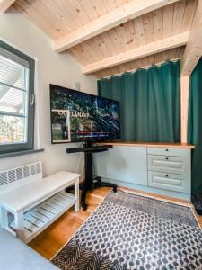 a bedroom with a desk and a large screen tv at Dom na Brzozowej in Gołubie