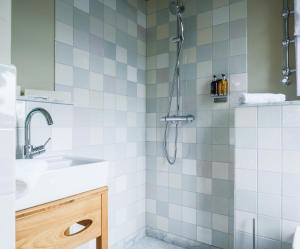 y baño con ducha y lavamanos. en Mimosa Suites en Westerland