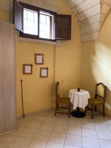 una stanza con un tavolo e due sedie e una finestra di CASE VACANZA ZOE - SOLE a Serrano