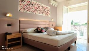 una camera da letto con un letto e una grande finestra di Hotel Villa Platani a Riccione