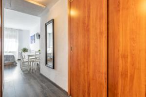 a hallway with a wooden door and a mirror at Apartment Hispalis Salado in Seville