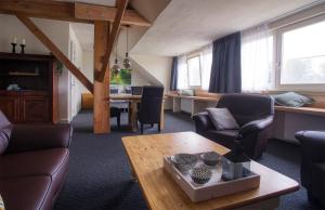 uma sala de estar com cadeiras e uma mesa e uma sala de estar em van Abelshoeve em Gieterveen