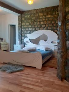 a bedroom with a bed and a stone wall at Barlogul Ursilor Lepsa in Lepşa