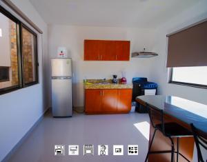 a kitchen with a refrigerator, sink and a window at Suite Isla Mujeres in Isla Mujeres