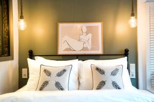 a bedroom with a bed with white pillows and a picture at Liman Hotel Gümüslük - Adult Only in Bodrum City