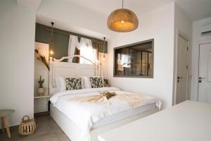 a bedroom with a white bed and a mirror at Liman Hotel Gümüslük - Adult Only in Bodrum City
