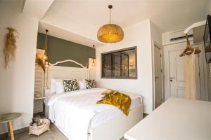 a bedroom with a white bed with a gold blanket on it at Liman Hotel Gümüslük - Adult Only in Bodrum City