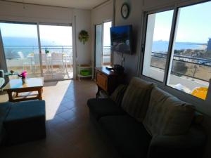 uma sala de estar com um sofá e vistas para o oceano em GMID IMMO Apartamento Oasis Atico em Roses