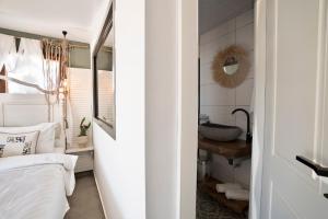 a bedroom with a sink and a bed and a mirror at Liman Hotel Gümüslük - Adult Only in Bodrum City