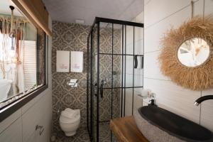 a bathroom with a tub and a toilet and a mirror at Liman Hotel Gümüslük - Adult Only in Bodrum City