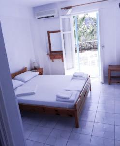 a bed in a room with a window and a bedvisor at Santa Maria Rooms in Agios Nikitas