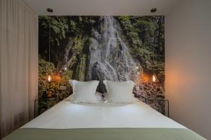 a bedroom with a waterfall mural on the wall at Senhora da Rosa, Tradition & Nature Hotel in Ponta Delgada