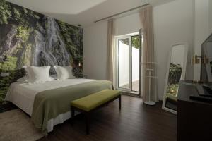 a bedroom with a bed and a large window at Senhora da Rosa, Tradition & Nature Hotel in Ponta Delgada