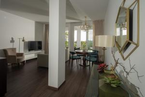 a living room with a table and a mirror at Senhora da Rosa, Tradition & Nature Hotel in Ponta Delgada