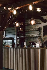 a bar in a restaurant with lights on the wall at Lødingen Brygge in Lødingen