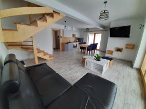 a living room with a couch and a staircase at Bajka w Gliczarowie in Bukowina Tatrzańska