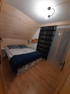 1 dormitorio con 1 cama en una habitación de madera en Bajka w Gliczarowie, en Bukowina Tatrzańska