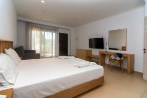 a bedroom with a large white bed and a television at Riviera Perdika Hotel in Perdika +37 photos