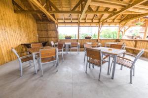 Vila Yna في مامايا نورد نافورداي: غرفة طعام مع طاولات وكراسي في مبنى