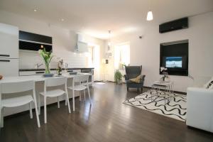 a living room with a white table and chairs at Carrera Corner Apartment in Rovinj +11 photos