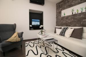 a living room with a couch and a chair at Carrera Corner Apartment in Rovinj